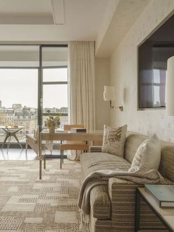 Geräumiges Hotelzimmer mit moderner Einrichtung und Blick auf die Stadt.