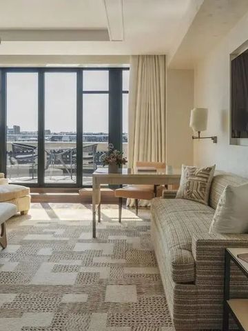 Helles Hotelzimmer mit komfortabler Sitzecke und Balkonzugang.