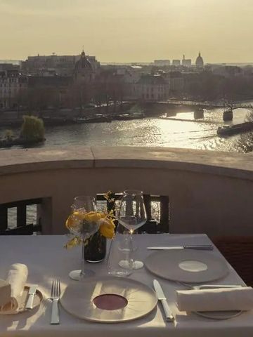 Terrasse mit gedecktem Tisch und Aussicht auf den Fluss bei Sonnenuntergang