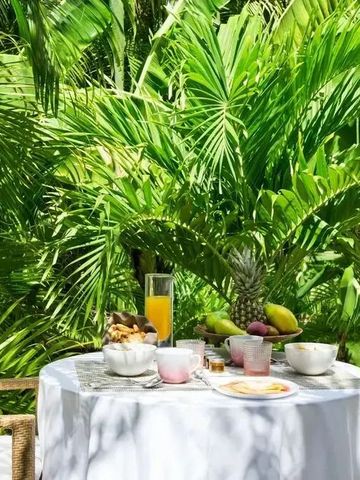 Tisch im Garten mit tropischen Früchten und Frühstück.