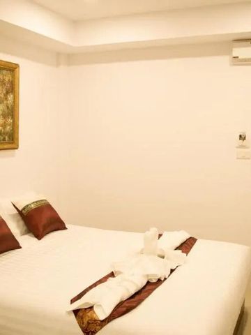 Schlafzimmer mit dekorativen Kissen und Wandkunst in warmer Beleuchtung