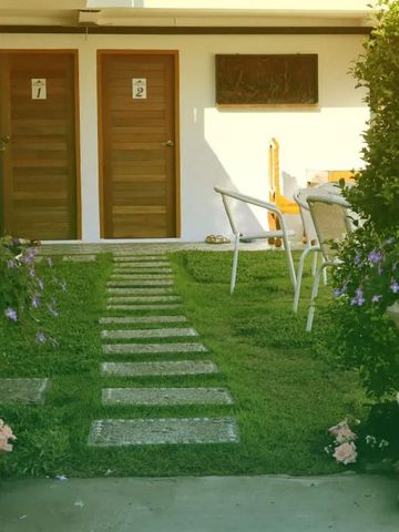 Grüner Gartenweg mit blühenden Pflanzen und Holztüren
