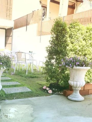 Hinterhof mit Pflanzen, Gartenmöbeln und Holzverkleidung