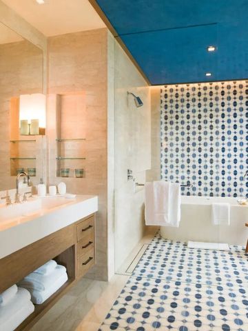 Badezimmer mit blauer Decke und Badewanne mit blauen Mosaikfliesen