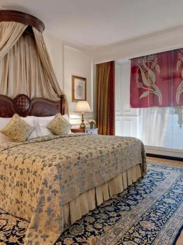 Klassisch eingerichtetes Zimmer mit Baldachin und Teppich