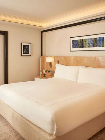 Bequemes Hotelzimmer mit moderner Kunst, hellem Holz und luxuriösem Doppelbett.