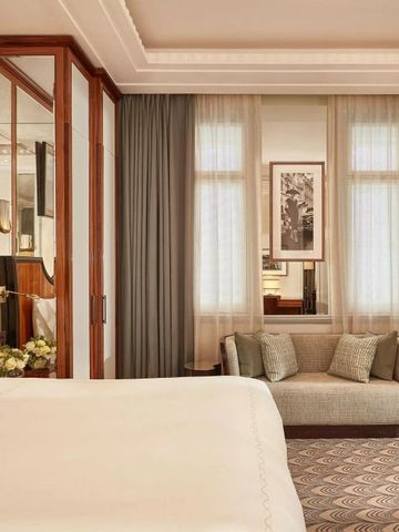 Luxuriös eingerichtetes Hotelzimmer mit großem Bett und eleganter Couch