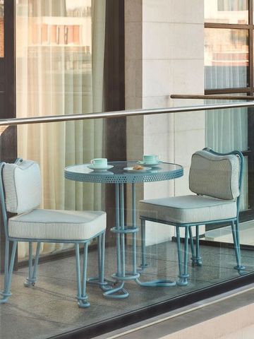 Balkon mit Gartenmöbeln und Blick auf die Stadt