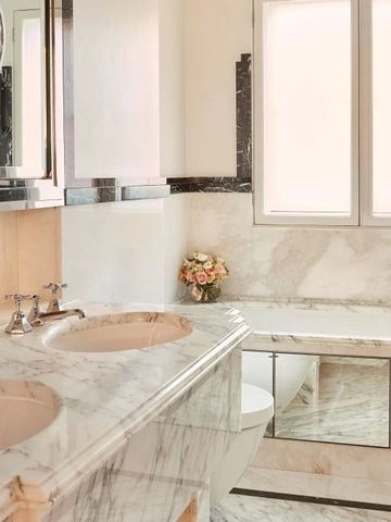 Luxuriöses Badezimmer mit Marmoroberflächen und Doppelwaschbecken