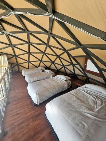 Dachgeschoss eines Geodoms mit vier Betten und Holzboden