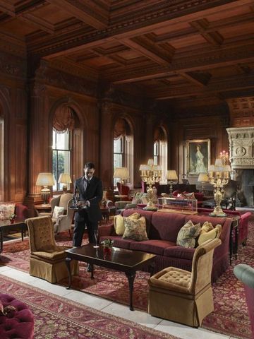 Elegante Lounge mit Holzvertäfelung und Kamin im Cliveden House.