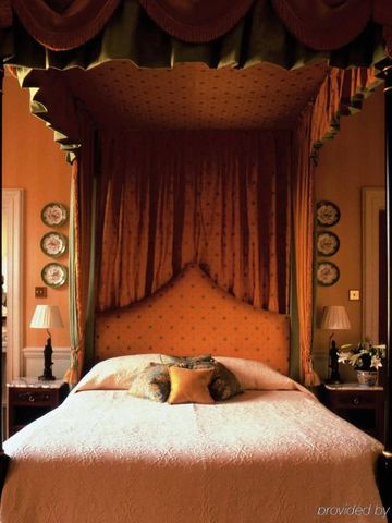 Stilvolles Schlafzimmer mit Himmelbett und dekorativen Vorhängen.