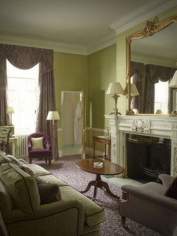 Eleganter Wohnbereich mit Kamin und klassischem Dekor im Hotelzimmer