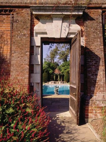 Offene Tür mit Blick auf den Garten und das Schwimmbad im Hintergrund
