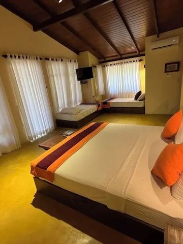 Helles Hotelzimmer mit Holzeinrichtung und großen Fenstern