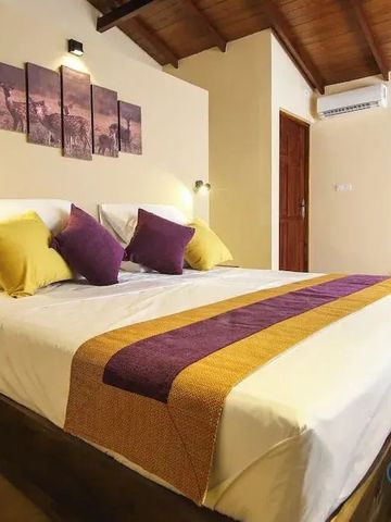 Hotelzimmer mit gemütlichem Bett und violetten Akzenten