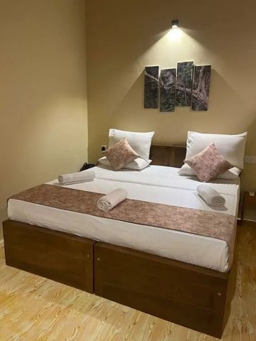 Einfaches Doppelzimmer mit dekorativen Kissen und ruhigem Ambiente