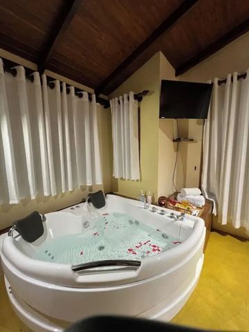 Innenaufnahme eines Badezimmers mit Sprudelbad und TV.