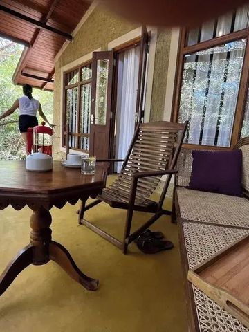 Terrasse mit Holzstühlen und Tisch umgeben von Natur