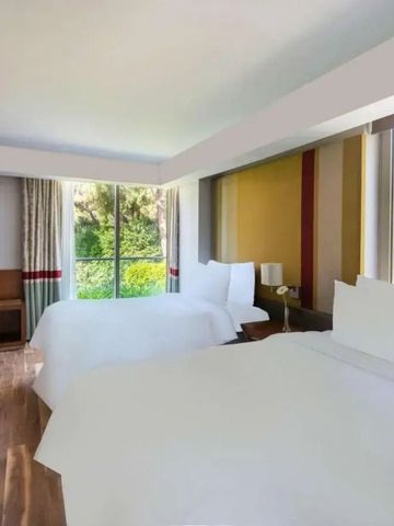 Helles, modernes Zweibettzimmer mit großen Fenstern und Gartenblick