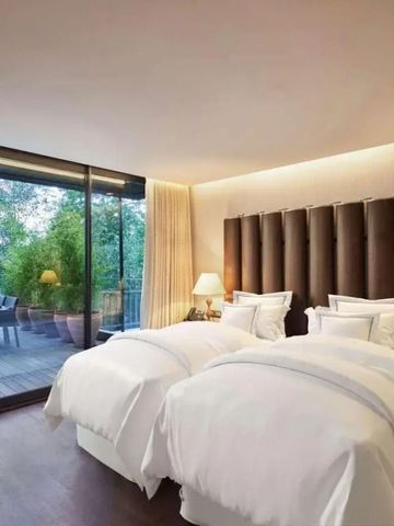 Elegantes Zimmer mit zwei Betten und großem Fenster zur Terrasse