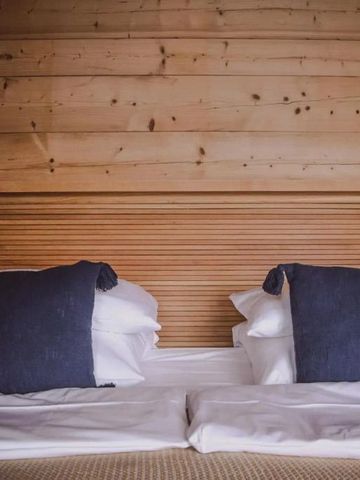 Doppelbett in einem Raum mit Holzverkleidung