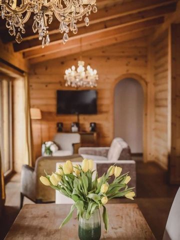 Heller Wohnbereich mit Holzwänden und Kronleuchter