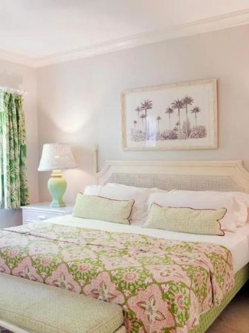 Lichtdurchflutetes Schlafzimmer mit tropischen Akzenten und Gemälden