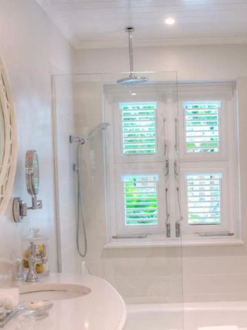 Helles, modernes Badezimmer mit Rundspiegel und Regendusche