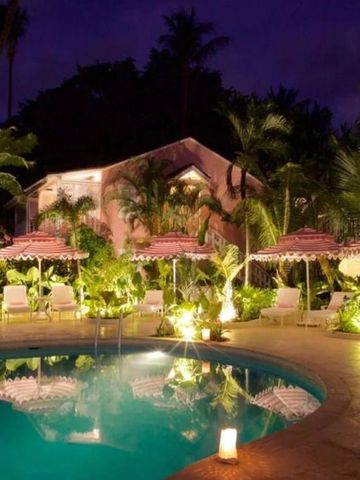 Beleuchteter Hotelpool bei Nacht mit tropischer Vegetation