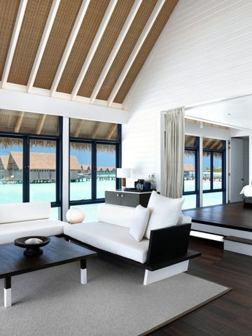 Helles Wohnzimmer mit großen Fenstern und Blick auf das Meer