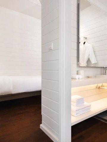 Elegant eingerichtetes Zimmer mit modernem Bad und Holzfußboden.