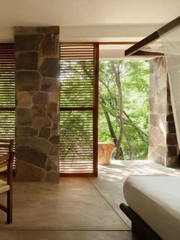 Zimmer mit Panoramablick auf die Natur durch eine große Fensterfront