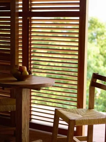 Gemütliche Sitzecke mit Holzmöbeln und Blick auf üppiges Grün