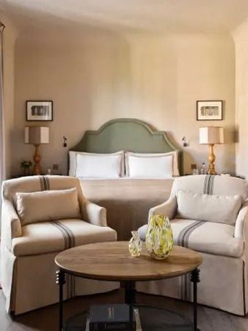 Gemütliches Schlafzimmer mit Doppelbett und Sitzbereich in warmen Farben.