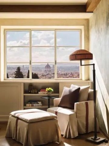 Heller Raum mit Sitzbereich und Panoramafenster mit Blick auf Florenz.