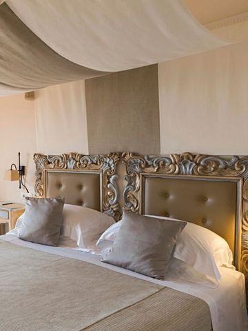 Zimmer mit aufwendig gestaltetem Betthaupt und Baldachin