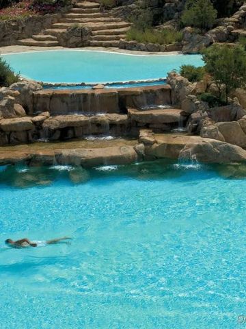 Kristallklarer Pool mit Wasserfällen im CPH Pevero Hotel