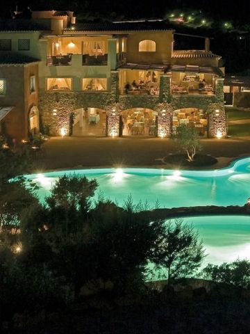 Beleuchtete Außenansicht des Hotelgeländes mit Pool bei Nacht