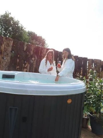 Zwei Personen entspannen bei Tageslicht im Whirlpool mit natürlicher Umgebung.