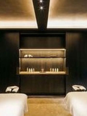 Dunkler Spa-Bereich mit Massageliegen und sanfter Beleuchtung