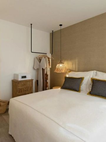 Hotelzimmer mit Doppelbett, schlichten Dekorelementen und sanfter Beleuchtung.