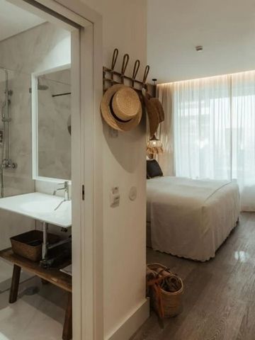 Modernes Hotelzimmer mit integriertem Bad und minimalistischer Einrichtung.