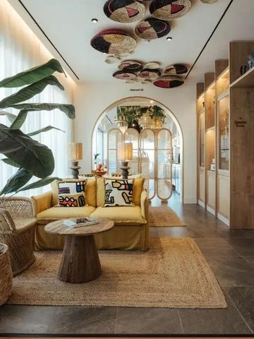 Moderne Hotel-Lounge mit Pflanzen und bunten Möbeln unter einer dekorativen Decke