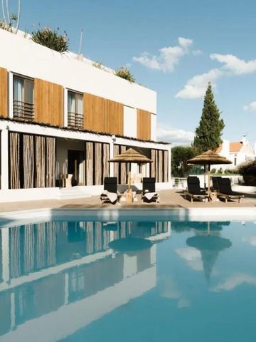 Außenansicht eines Pools mit Liegestühlen und moderner Architektur im Hintergrund