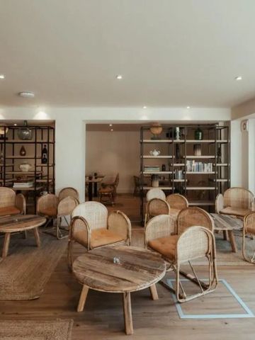Gemütliche Hotel-Lounge mit Rattanmöbeln und Bücherregalen