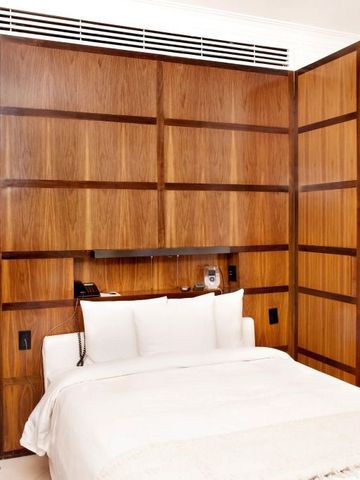 Elegantes Zimmer mit Holzwand und komfortablem Bett