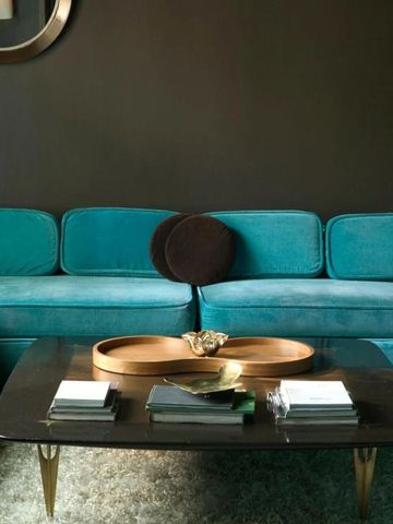 Moderne Lounge mit türkisfarbenen Sofas und elegantem Tisch