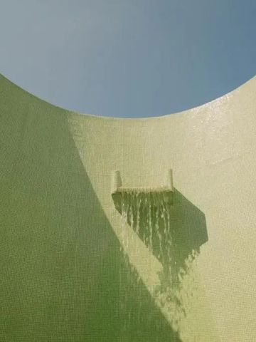 Künstlerischer Wasserfall in runder Betonwand mit Tageslichtöffnung