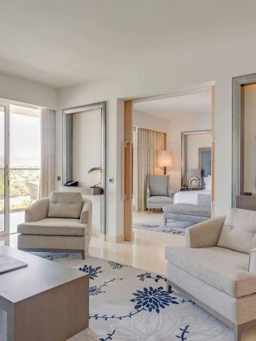 Geräumiger Wohnbereich einer Suite mit hellen Farben und stilvollem Design im Conrad Algarve.